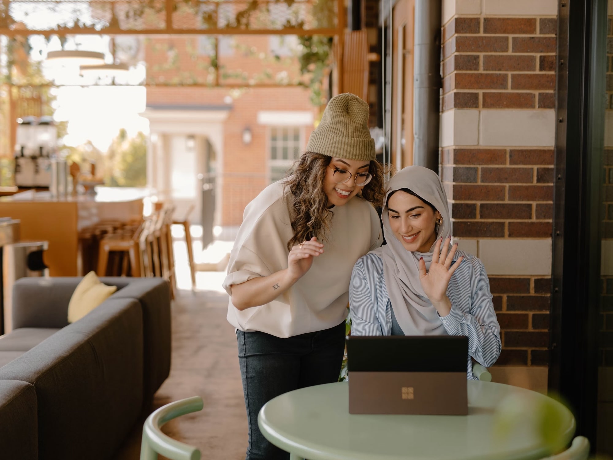 A DeRivian carer sharing a warm moment with a client at home, both looking at a laptop together